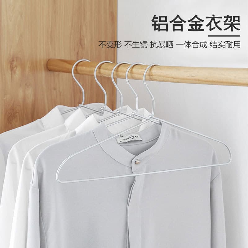 Cabide de alumínio branco para roupas com camisetas penduradas em um suporte de madeira