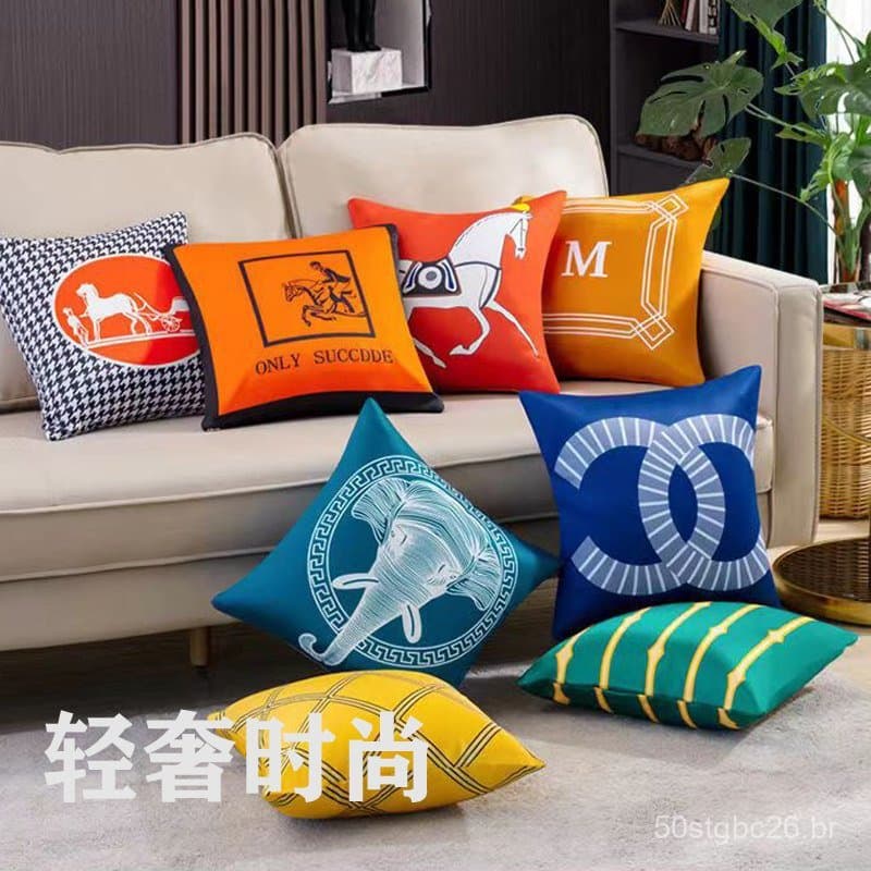 Almofadas de sofá estilo americano com designs únicos, como cavalo, elefante e letra M, dispostas em uma sala de estar.