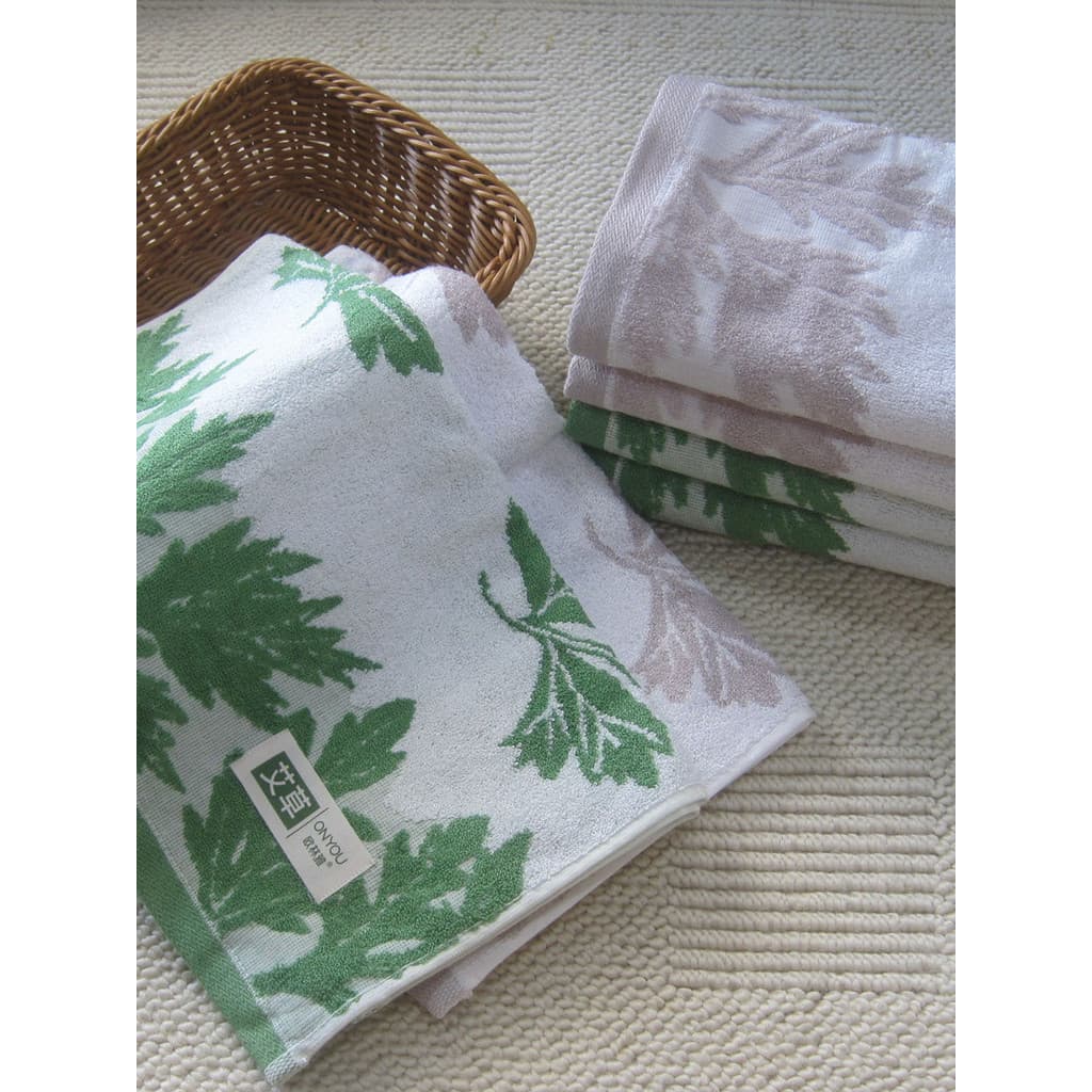 Toalha de banho verde e branca com padrão de folhas de bambu