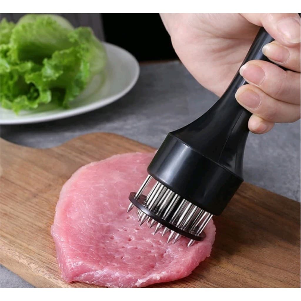 Amaciador batedor de carne com furador em aço inox aplicado em um pedaço de carne