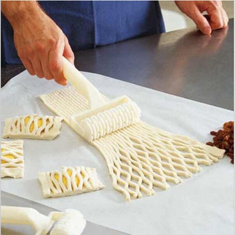 Cortador de massa criando padrões em massa amarela sobre superfície de trabalho