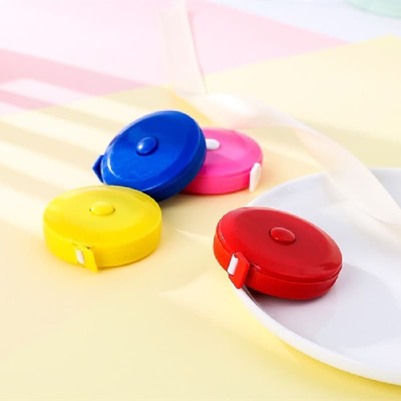 Fitas métricas retráteis de cores diferentes em fundo multicolorido