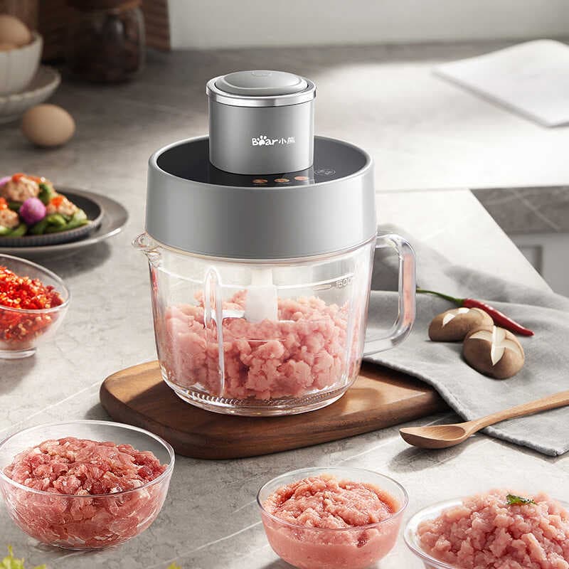 Moedor de carne elétrico Pequeno Urso QSJZHY-F03X2, cinza escuro, 2L, em uma cozinha com ingredientes e tigelas de carne picada.