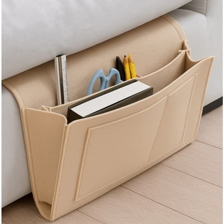 Bolso de armazenamento de cabeceira bege com régua, tesoura, lápis e livro dentro.