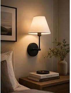 Luminária de parede minimalista preto e branco iluminando uma mesa com livros e uma planta.