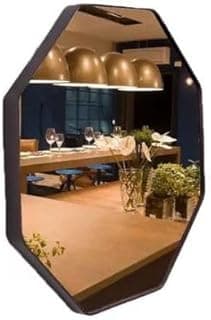 Espelho octogonal decorativo com alça de couro, refletindo sala de jantar com mesa e luminárias pendentes.