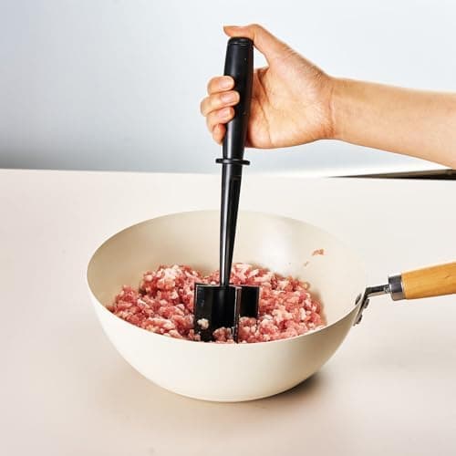 Picador de carne manual preto em uso em uma tigela de carne moída