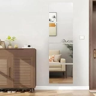 Espelho autoadesivo de comprimento total sem moldura refletindo uma sala com sofá e plantas