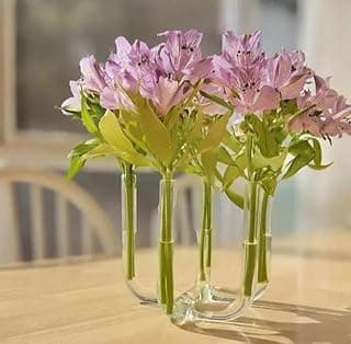 Arranjo floral em vaso de vidro transparente com design moderno de tubos