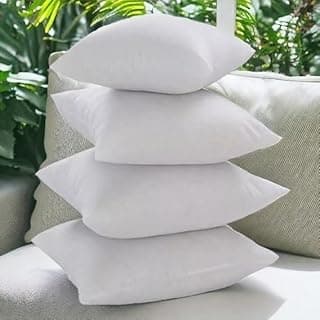 Kit de quatro almofadas decorativas brancas para sofá, em fundo verde e cinza.