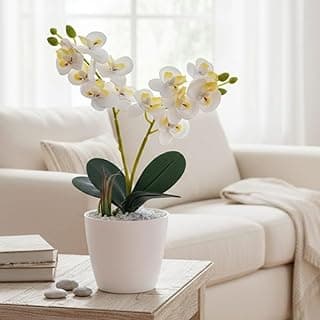 Mini orquídea branca artificial em vaso branco sobre mesa de madeira