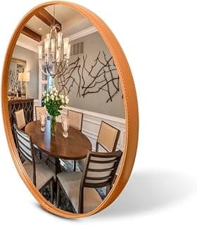 Espelho redondo com borda de couro caramelo refletindo sala de jantar