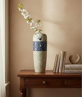Vaso decorativo de porcelana azul e branco com flores brancas, ideal para decoração de mesa central ou sala.