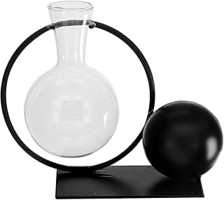 Vaso de vidro transparente com anel de metal preto e esfera preta sobre base retangular preta