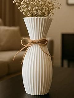 Vaso decorativo canelado branco com flores e fita marrom em fundo bege