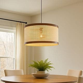 Luminária pendente de teto com tela rattan redonda, iluminando uma mesa com uma planta.