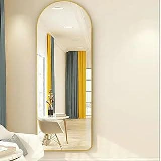 Espelho oval dourado em pé com suporte para o corpo inteiro refletindo sala com mesa e cadeiras