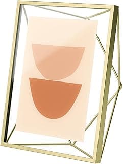 Porta retrato prisma em aço dourado com moldura quadrada e formas semicirculares em tons de rosa e laranja.