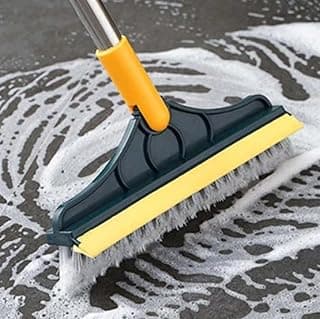 Escova de limpeza 2 em 1 com cerdas brancas e amarelas, em movimento sobre uma superfície úmida.
