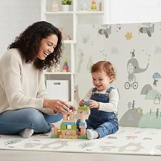 Mãe e bebê brincando com blocos de construção em um tapete infantil dobrável branco com desenhos coloridos.