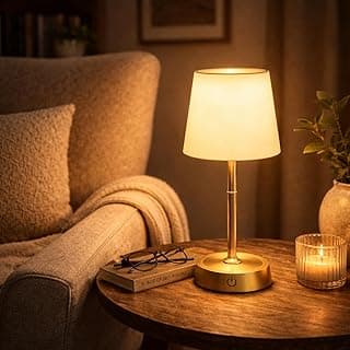 Luminária de mesa moderna com cúpula branca e base dourada em um ambiente aconchegante