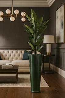Vaso alto verde com efeito marmorizado contendo planta alta em sala de estar sofisticada com decoração moderna
