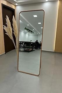 Espelho retangular com moldura em bronze 170x70 cm refletindo ambiente