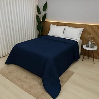 Edredom azul marinho em cama de solteiro com decoração minimalista