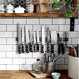 Utensílios de cozinha pendurados em uma barra magnética na parede de azulejos brancos