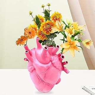 Escultura de resina em forma de coração rosa com flores amarelas e laranjas