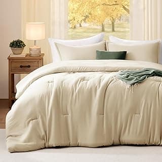Conjunto de edredom king de linho Quataly, cor bege, em uma cama com almofadas e vista para uma paisagem verde.