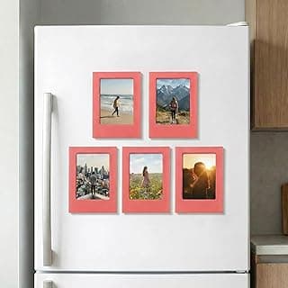 Porta-retratos magnéticos cor-de-rosa em um refrigerador branco