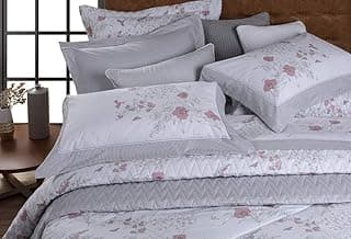 Edredom Queen com estampa floral cinza e rosa em um colchão com travesseiros