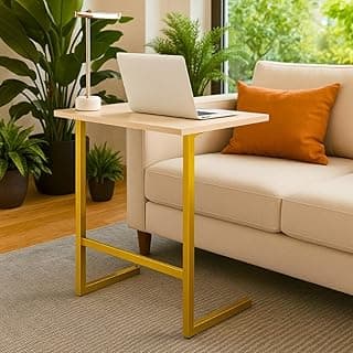 Mesa escrivaninha portátil amarela e de madeira sobre sofá bege com laptop e lâmpada.