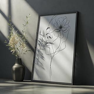 Quadro decorativo minimalista com rosto feminino e flor, moldura preta e branco, fundo cinza, vaso preto com flores brancas