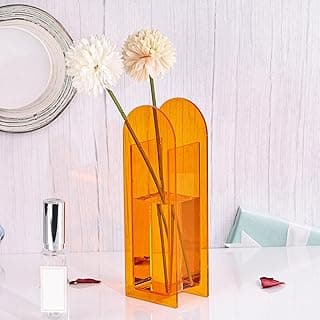 Vaso de acrílico laranja geométrico moderno com flores brancas em uma mesa