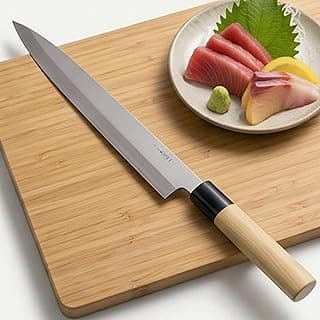 Faca japonesa longa e fina com lâmina de aço inoxidável e cabo de madeira sobre tábua de corte com sashimi.