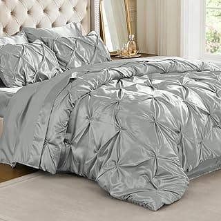 Conjunto de edredom de cetim prateado com detalhes de babado em uma cama luxuosa