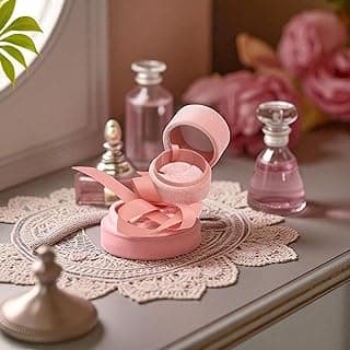 Caixa de joias cilíndrica rosa com fita de pelúcia em toalhete branco