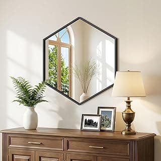 Espelho hexagonal preto montado na parede com reflexo de janela e plantas