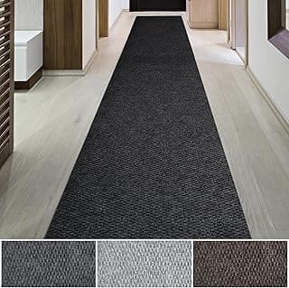 Tapete preto antiderrapante para uso interno e externo, colocado em um corredor com piso de madeira.