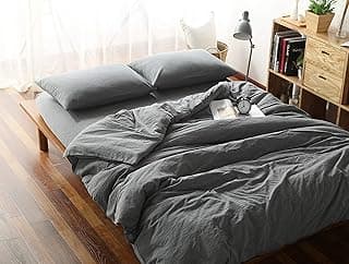 Edredom cinza em cama com travesseiros e decoração minimalista
