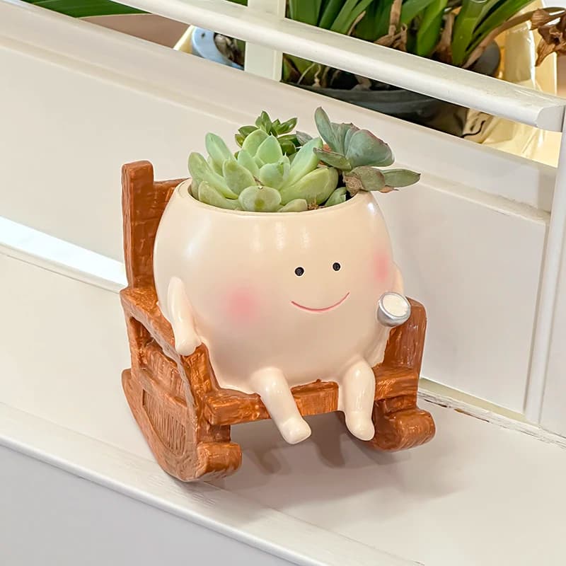 Cadeira de balanço em forma de ovo com rosto sorridente e planta suculenta