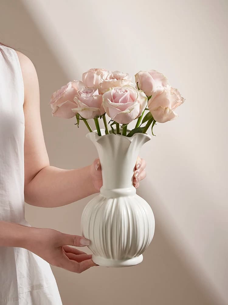 Vaso de cerâmica branco em formato de abóbora com rosas brancas