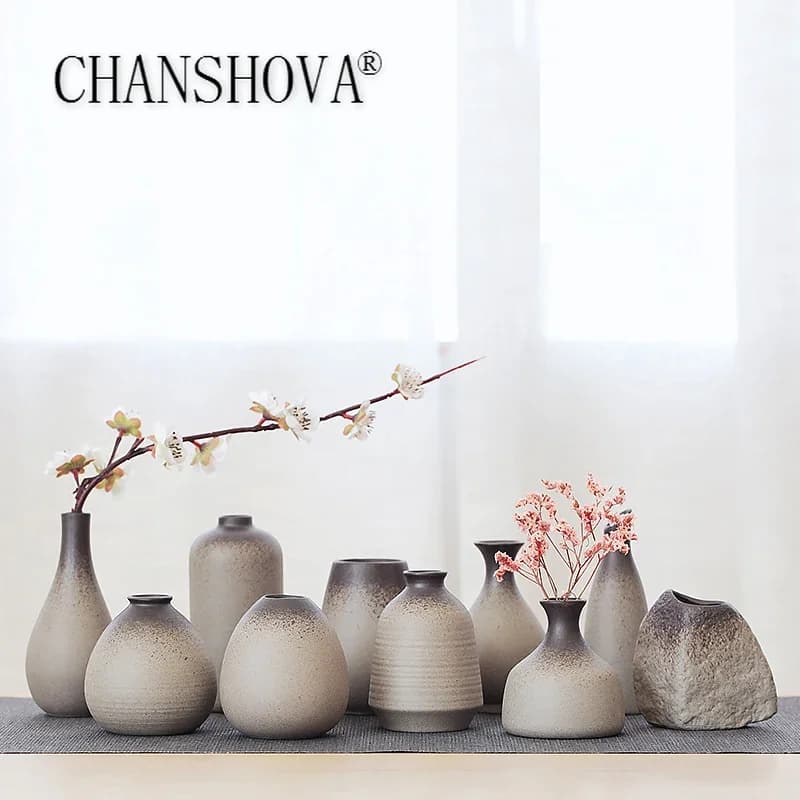 Vasos de cerâmica cinza com flores brancas e rosas, estilo retro, decoração moderna.